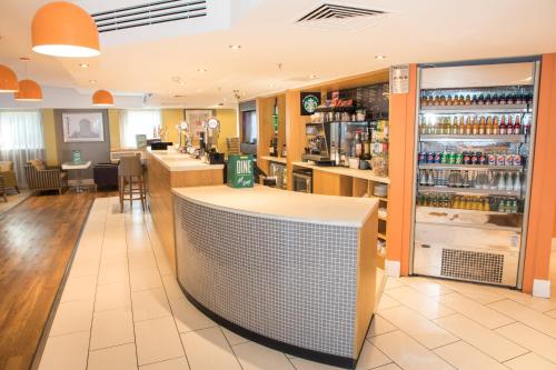 a bar in a restaurant with a counter at Holiday Inn Slough Windsor by IHG in Slough