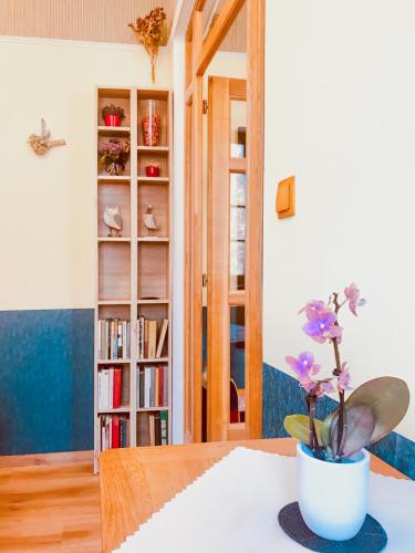 a room with a table with a vase with flowers on it at Golden Wood Apartments in Plzeň