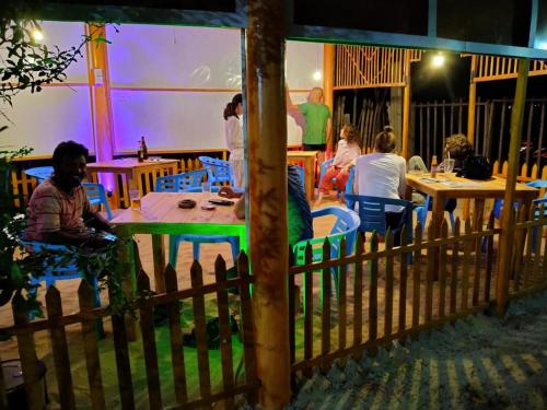un grupo de personas sentadas en mesas en un restaurante en Vibushan Guest House en Nilaveli