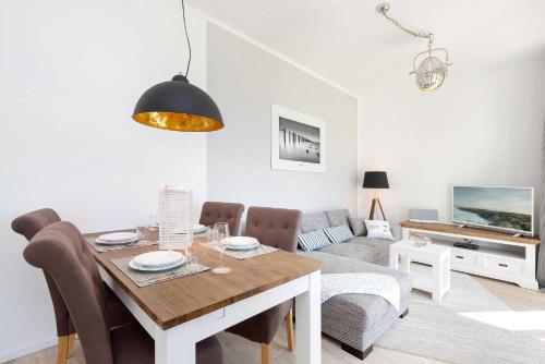 - un salon avec une table à manger et un canapé dans l'établissement Villa Wiederkehr Heimkehr, à Sellin