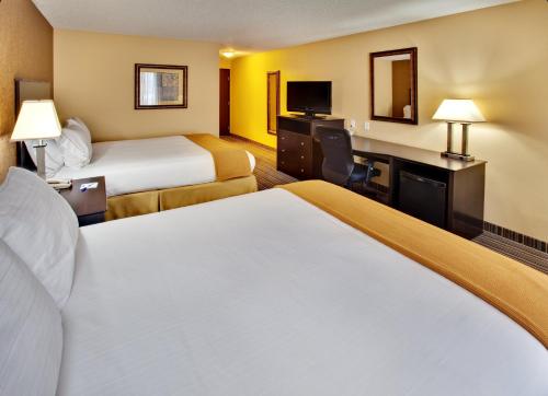 a hotel room with two beds and a desk at Holiday Inn Express Hotel & Suites Council Bluffs - Convention Center Area by IHG in Council Bluffs