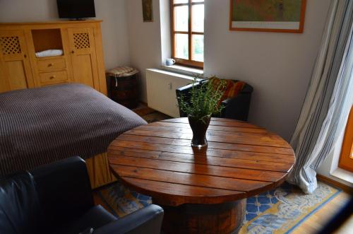 een woonkamer met een houten tafel en een bed bij Kleiner-Burgblick in Leisnig
