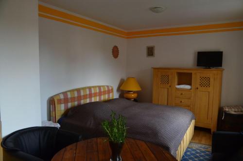 1 dormitorio con cama y mesa de madera en Kleiner-Burgblick, en Leisnig