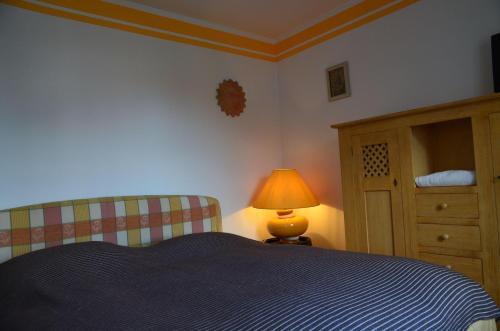 een slaapkamer met een bed, een lamp en een dressoir bij Kleiner-Burgblick in Leisnig