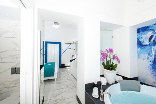 a bathroom with white walls and a blue sink at Positano Art Hotel Pasitea in Positano
