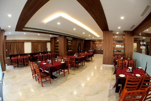 a restaurant with tables and chairs in a room at Rathna Residency in Salem