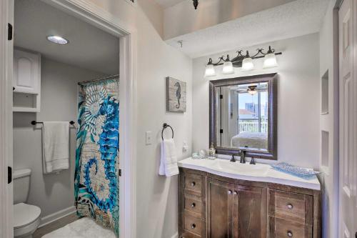 y baño con lavabo, espejo y aseo. en Snowbirds Retreat Walkable Destin Condo with View! en Destin