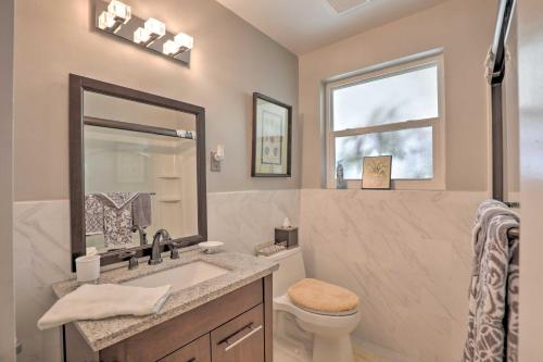 a bathroom with a sink and a toilet and a window at Single-Story Home Walk to Beach, Pier and River in Ormond Beach