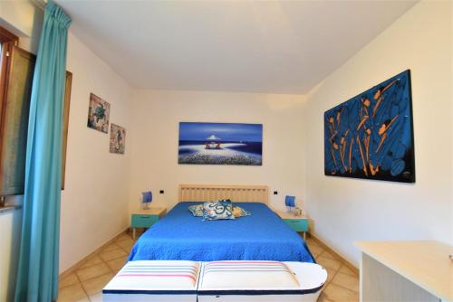 a bedroom with a blue bed and two tables at La Risacca in San Vincenzo
