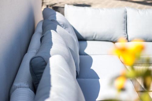 サントロペにあるル マ ベルビューの白い枕と黄色い花の青いソファ