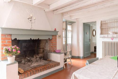 een woonkamer met een open haard en een tafel bij Agriturismo Conte Brunello in Salò