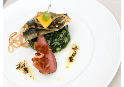 a white plate topped with food on a table at Boutique Hotel Esplanade - Adults only in Crikvenica