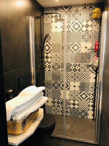 La salle de bains est pourvue d'une douche et d'un mur en carrelage. dans l'établissement Cannes Beach, à Cannes