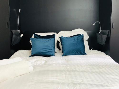 - un lit blanc avec 2 oreillers bleus dans l'établissement Cannes Beach, à Cannes