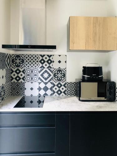 - une cuisine avec du carrelage noir et blanc sur le mur dans l'établissement Cannes Beach, à Cannes