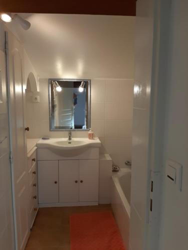 une salle de bain avec un lavabo, un miroir et une baignoire dans l'établissement LES LAURIERS, au Castellet