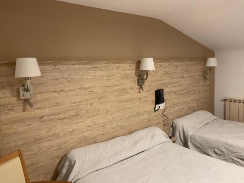 a bedroom with two beds and a phone on the wall at Le bistrot d eugenie in Eugénie-les-Bains