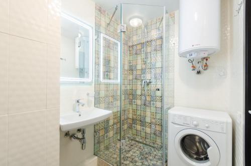 a bathroom with a washing machine and a sink at ARTAL Apartment on Obolonsky avenue 31 in Kyiv