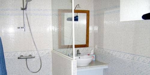 y baño blanco con lavabo y ducha. en La Chaumière de la Chaize, en Saint-Jouan-des-Guérets