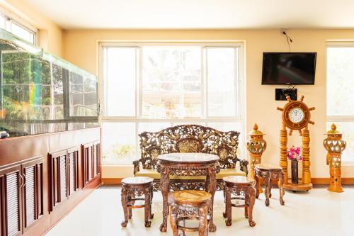 een woonkamer met een tafel, stoelen en een bank bij M Resort in Songkhla