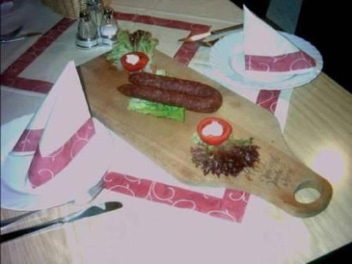 a wooden cutting board with a sausage and tomatoes on it at Reit- und Ferienhof Emstal in Fritzlar