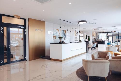 a lobby with chairs and a counter in a store at Antunović Hotel East in Sesvete