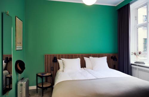 a green bedroom with a white bed and a green wall at Coco Hotel in Copenhagen