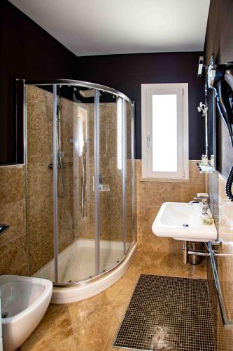 a bathroom with a shower and a sink at Hotel Boutique Carolina in Marina di Castagneto Carducci