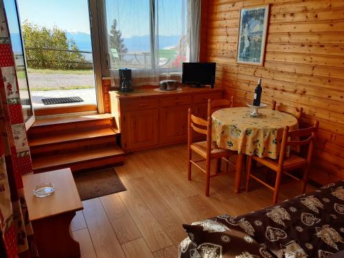 une pièce avec une table, des chaises et une télévision dans l'établissement Chalet Les Lupins T2, à Font-Romeu