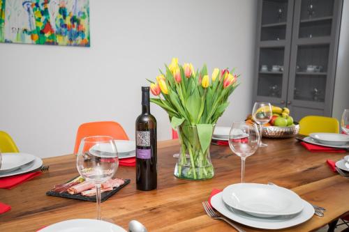 a table with a bottle of wine and a vase of flowers at Kuće za odmor -Japin breg in Ðurđevac