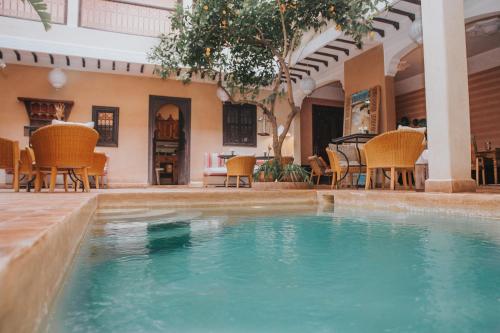 a swimming pool with a pool table and chairs at Riad l'Oiseau du Paradis in Marrakesh