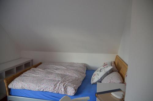 a small bedroom with a bed with blue sheets at Bickbargen in Halstenbek