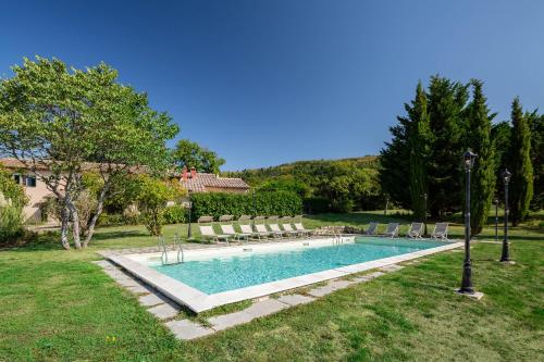 a swimming pool in a yard with chairs and a house at Portion of Villa with Private pool in Vaglia