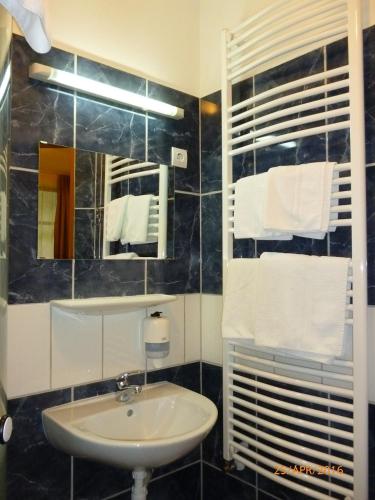 a bathroom with a sink and a mirror and towels at Mátraházai Üdülőház in Mátraháza