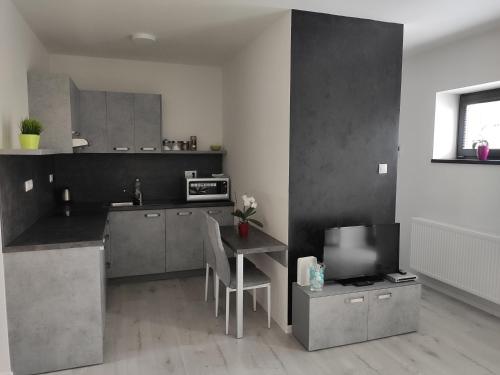 a kitchen with a table and a tv in it at Apartman Kuzmanyho Žilina centrum in Žilina