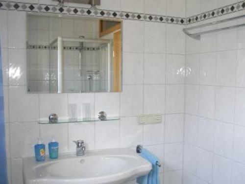 a white bathroom with a sink and a mirror at Ferienwohnungen Dippold in Scheßlitz