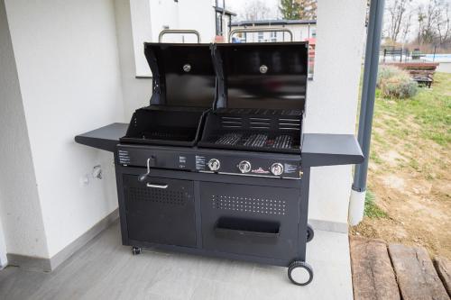 a black barbecue grill sitting on a porch at Kuće za odmor -Japin breg in Ðurđevac