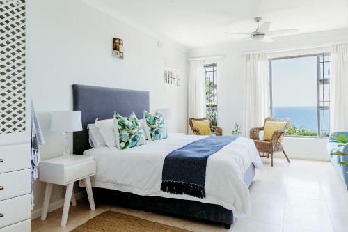 um quarto branco com uma cama grande e uma janela em Eden View Cottage, Sheffield Beach em Sheffield Beach