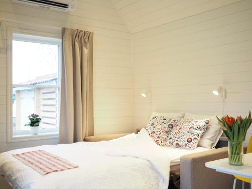 una camera con un letto con una finestra e un cuscino di Kristina Attefall i Västerhaninge a Västerhaninge