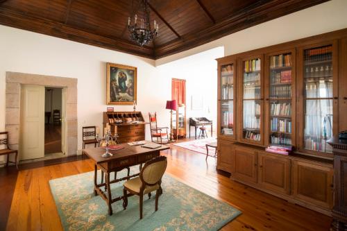 a living room with a wooden table and a dining room at Casa do Condado de Beirós in São Pedro do Sul