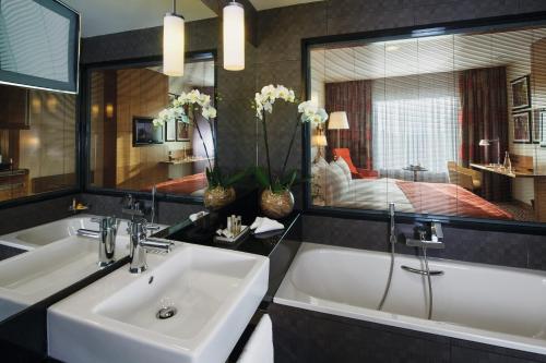 a bathroom with two sinks and a large mirror at Movenpick Hotel Ankara in Ankara