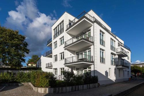 un edificio blanco con balcones en un lateral en Villa Wiederkehr Einkehr, en Ostseebad Sellin
