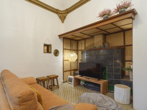 sala de estar con sofá y chimenea en APG Palau Salieti 3, en Girona