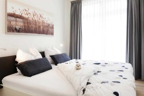 ein Schlafzimmer mit einem weißen Bett mit einem Teddybär darauf in der Unterkunft Villa Wiederkehr Einkehr in Ostseebad Sellin