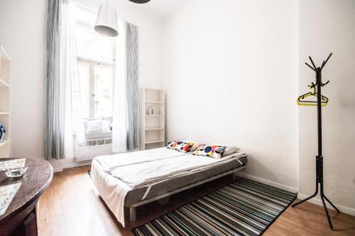 een witte kamer met een bed en een raam bij Apartment in the center of Warsaw in Warschau