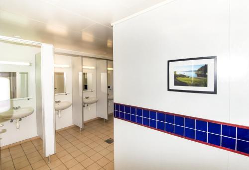 a bathroom with two sinks and blue tiles at Bergen Camping Park in Bergen