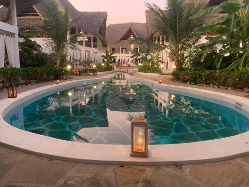a pool at a resort with a light in the middle at Rafiki Village in Watamu