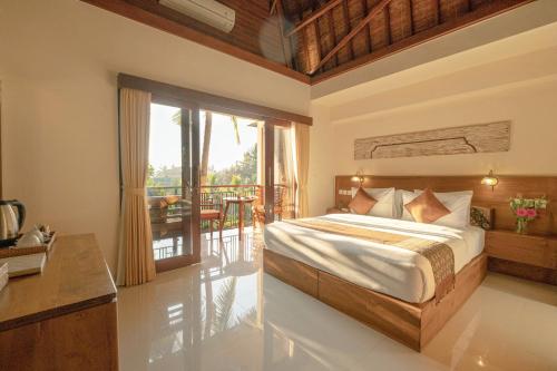 um quarto com uma cama e uma varanda em Gunung Merta Bungalows em Ubud