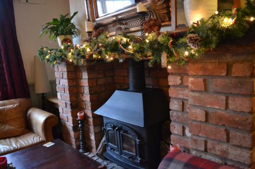 a fire place in a brick building with a christmas tree at Halfway House in Great Malvern