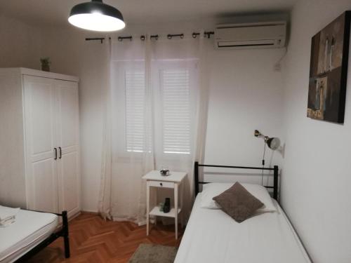 a small bedroom with two beds and a window at Guesthouse Radić in Dubrovnik